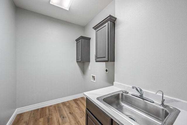 laundry room with cabinets, sink, hookup for an electric dryer, light hardwood / wood-style flooring, and hookup for a washing machine