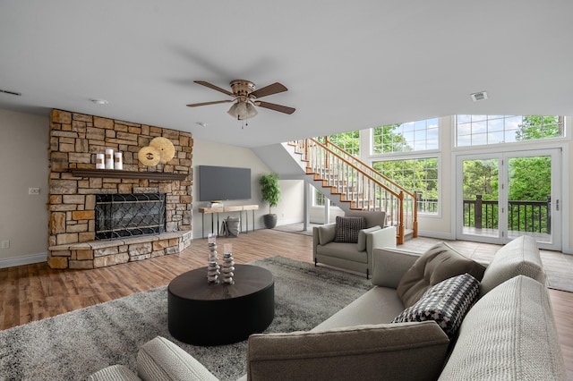 living room featuring a fireplace, light hardwood / wood-style floors, and ceiling fan