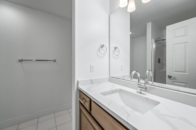 bathroom with an enclosed shower, vanity, and tile patterned floors