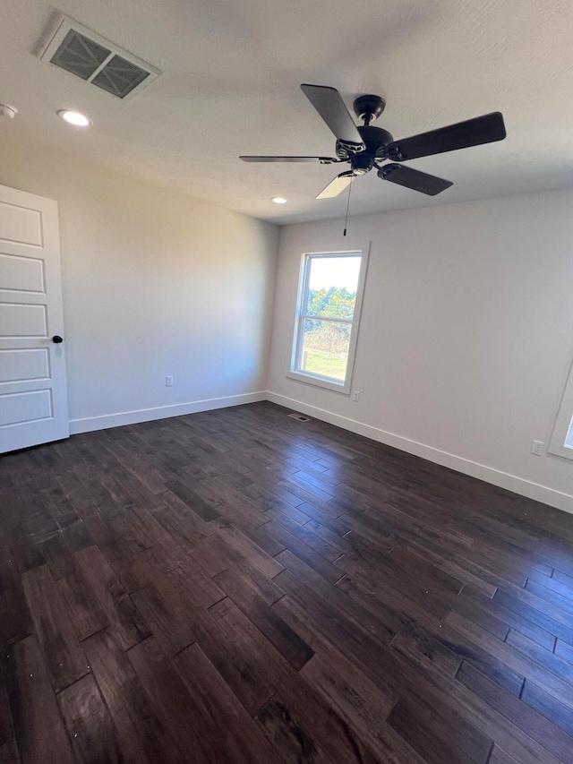 spare room with dark wood-type flooring, recessed lighting, visible vents, and baseboards