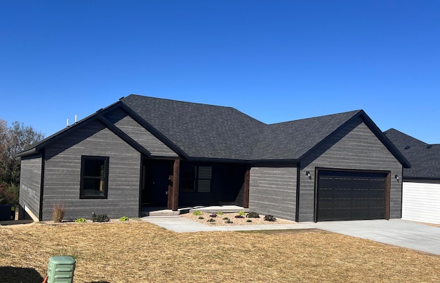 ranch-style home with a garage, concrete driveway, and a shingled roof