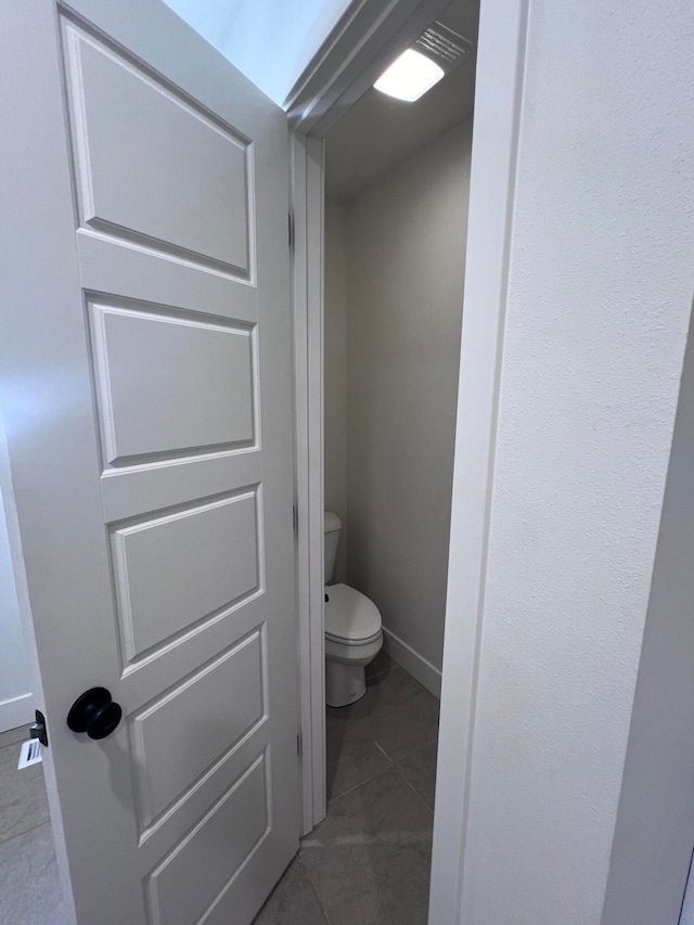 bathroom with toilet and baseboards