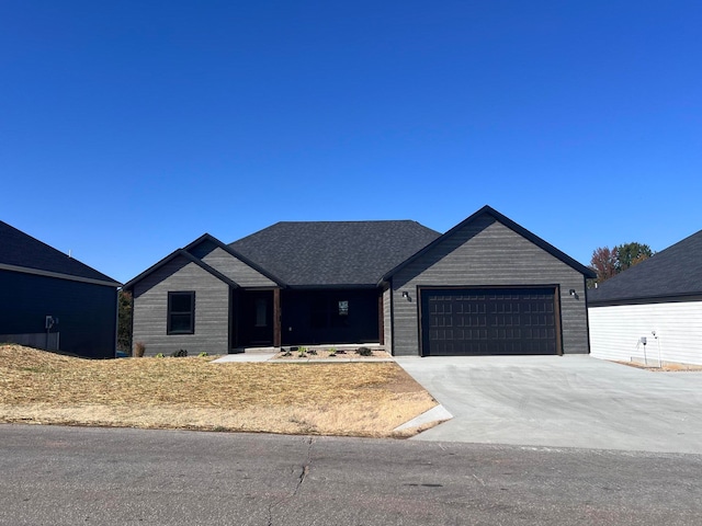 view of front of home with concrete driveway and an attached garage