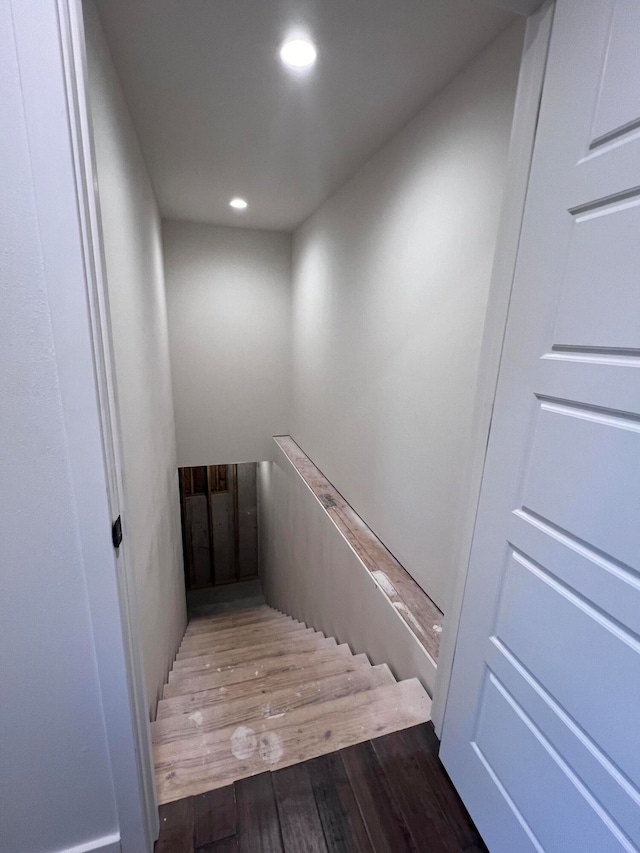 stairway with recessed lighting and wood finished floors