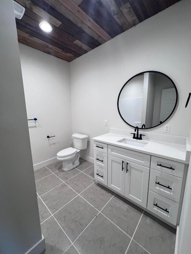 bathroom with baseboards, toilet, wood ceiling, tile patterned floors, and vanity