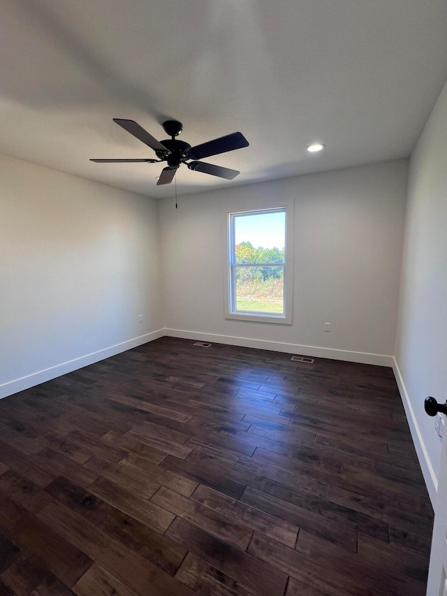 empty room with recessed lighting, dark wood-type flooring, a ceiling fan, visible vents, and baseboards