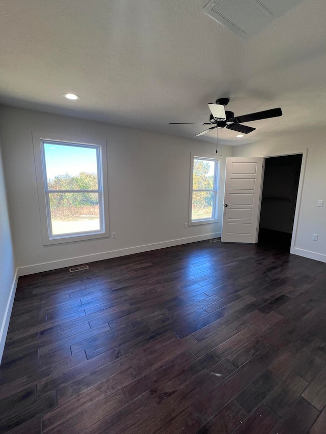 spare room with baseboards, visible vents, dark wood finished floors, and recessed lighting