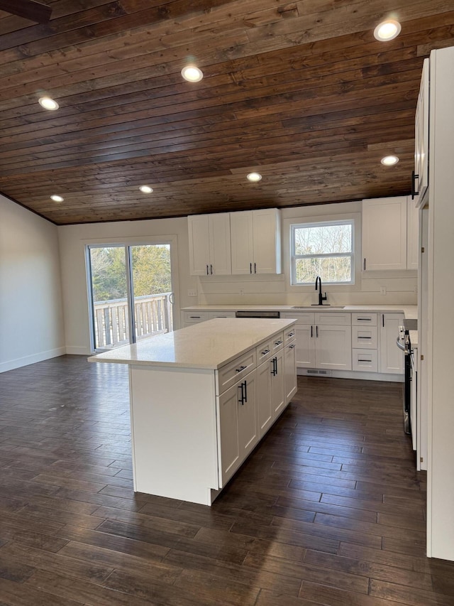 kitchen with dark wood-style flooring, wooden ceiling, and a sink