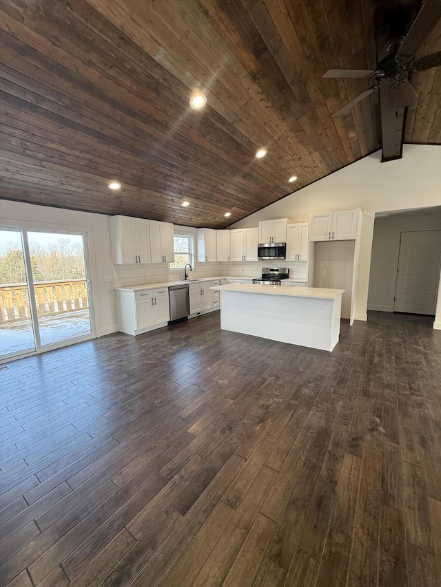 kitchen with appliances with stainless steel finishes, wood ceiling, a sink, and dark wood-style flooring