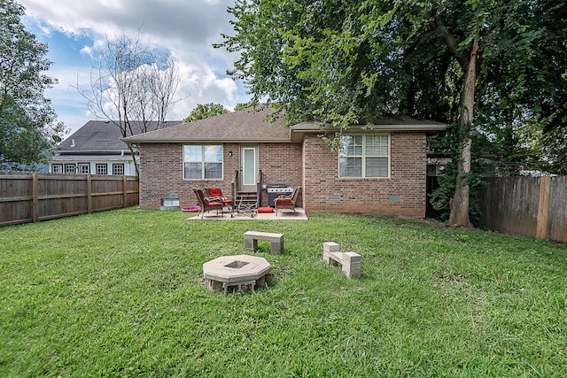 rear view of property featuring a patio area, a yard, and an outdoor fire pit