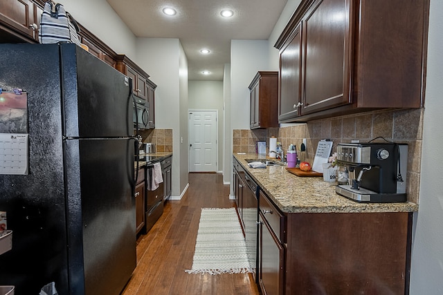 kitchen featuring black appliances, dark hardwood / wood-style flooring, sink, and dark brown cabinetry