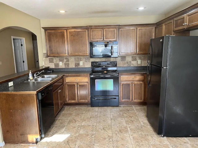 kitchen with kitchen peninsula, sink, black appliances, and decorative backsplash