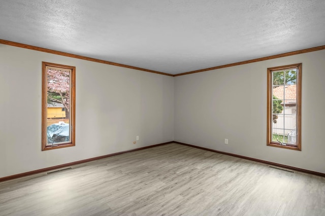 empty room featuring ornamental molding, a textured ceiling, and light hardwood / wood-style floors