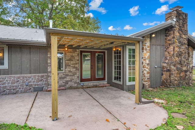 view of exterior entry featuring a patio area and french doors