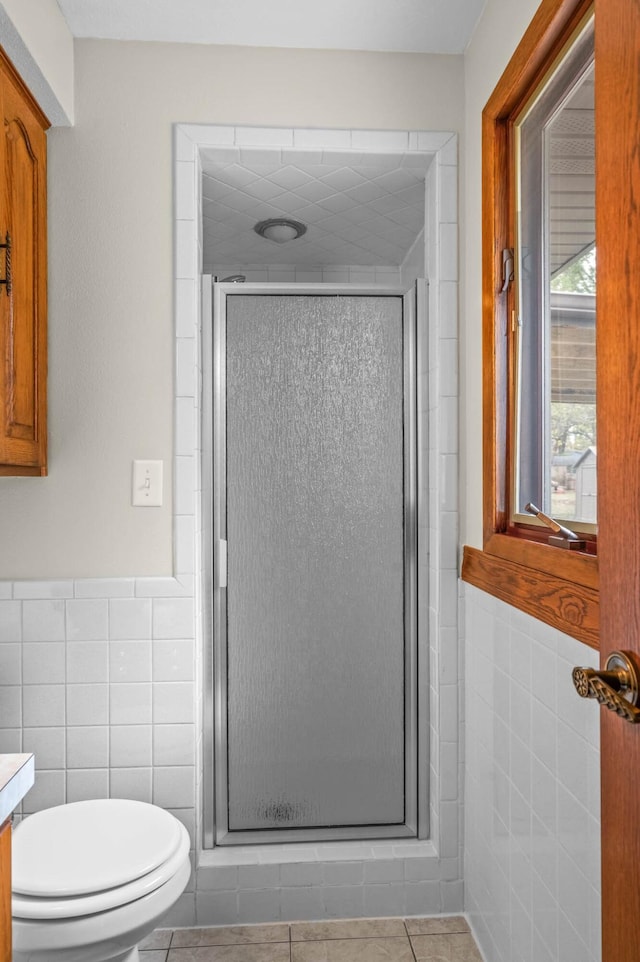 bathroom featuring vanity, tile walls, tile patterned flooring, and a shower with door