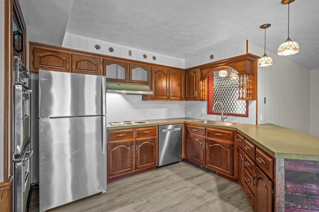 kitchen with light hardwood / wood-style floors, sink, pendant lighting, appliances with stainless steel finishes, and wine cooler