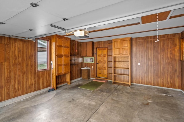 garage featuring wood walls and a garage door opener