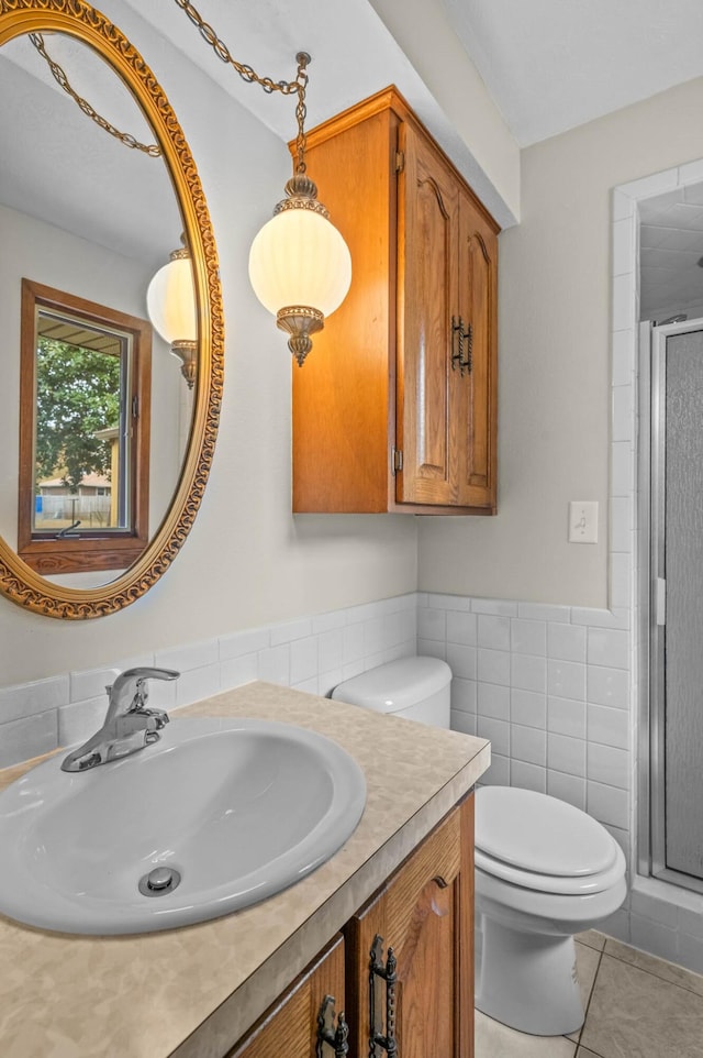 bathroom featuring tile patterned floors, toilet, tile walls, an enclosed shower, and vanity