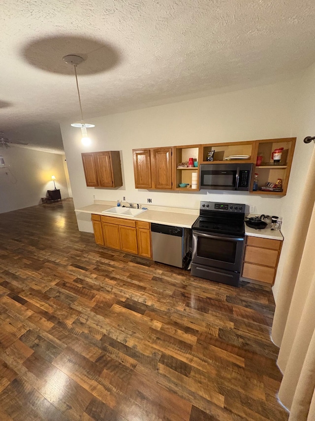 kitchen with sink, dark wood-type flooring, a textured ceiling, and appliances with stainless steel finishes