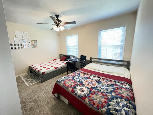 bedroom featuring ceiling fan, multiple windows, and carpet