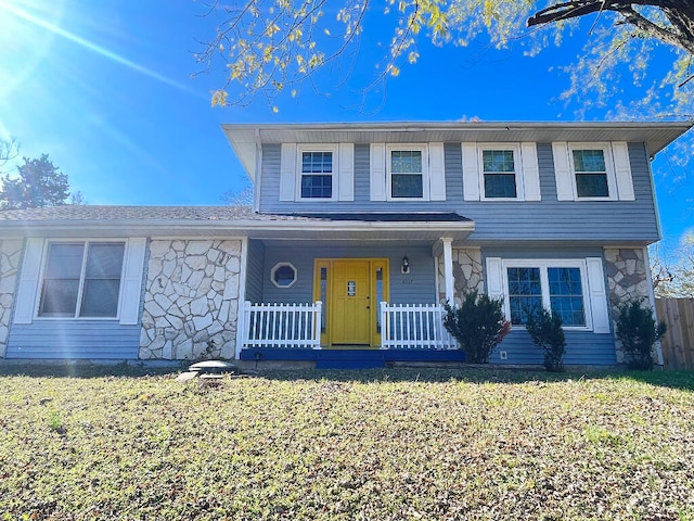 view of property featuring a front lawn and covered porch