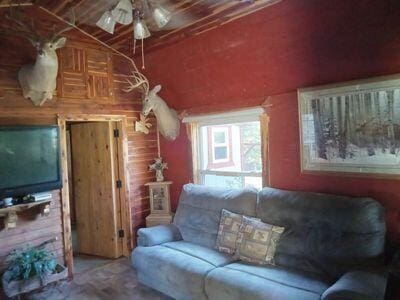 living room featuring vaulted ceiling and ceiling fan