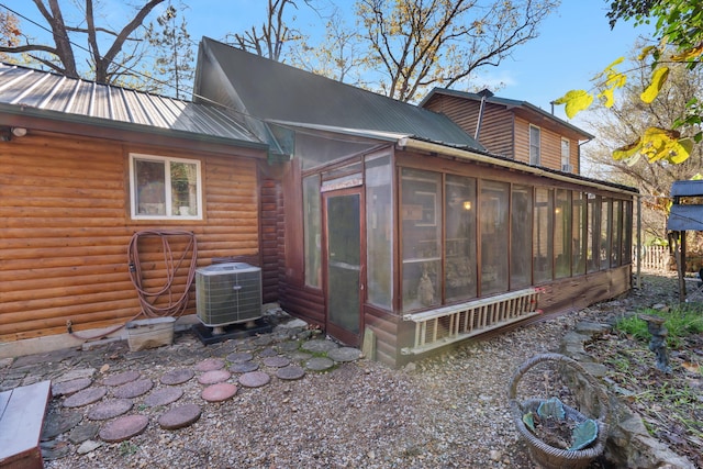 rear view of house with a sunroom and central air condition unit