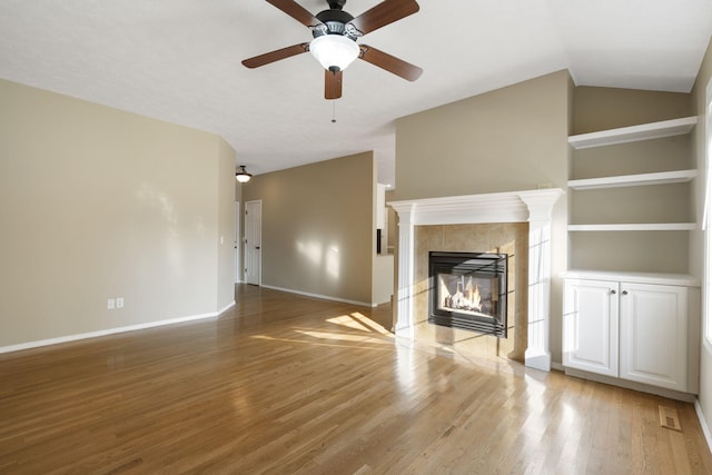 430 S Yellowwood Dr, Springfield, MO 65809 - unfurnished living room featuring baseboards, light wood-style floors, built in shelves, vaulted ceiling, and a ceiling fan