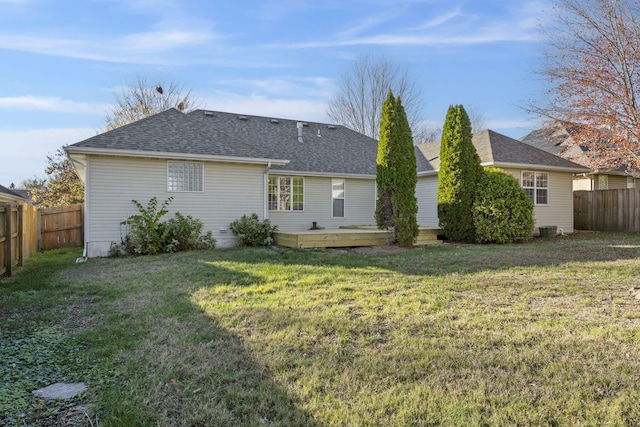 rear view of property featuring a lawn and a deck