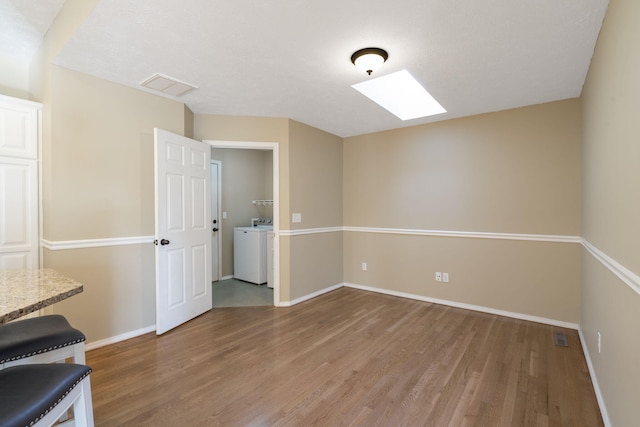 430 S Yellowwood Dr, Springfield, MO 65809 - unfurnished room featuring washer / clothes dryer, light wood-type flooring, a skylight, and baseboards