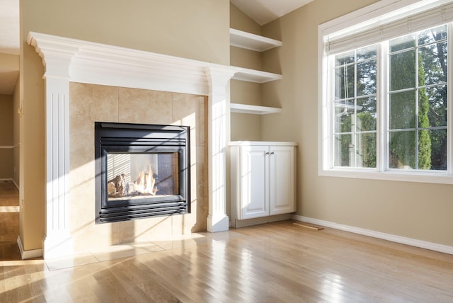 430 S Yellowwood Dr, Springfield, MO 65809 - unfurnished living room with light wood finished floors, baseboards, and a tile fireplace