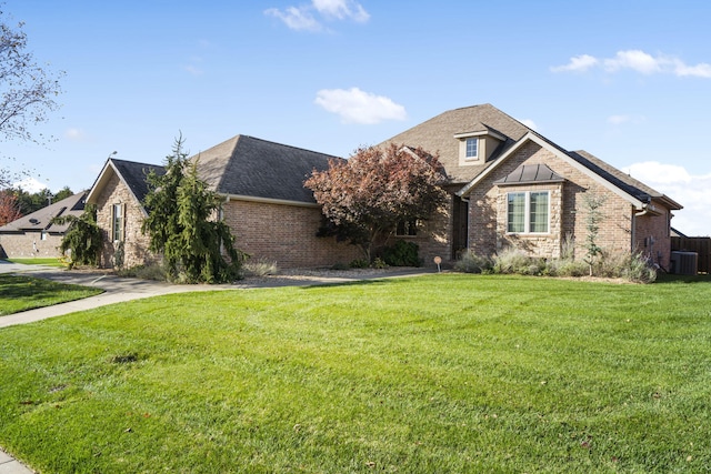 view of front of home featuring cooling unit and a front yard