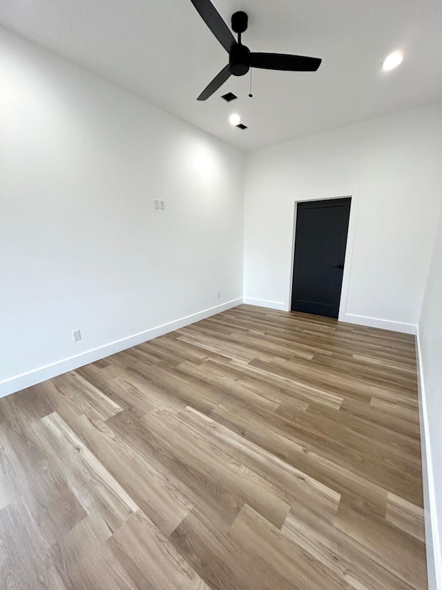 empty room featuring ceiling fan and light hardwood / wood-style floors