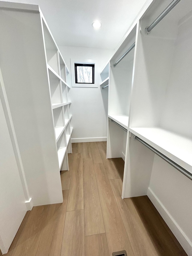 walk in closet with light wood-type flooring