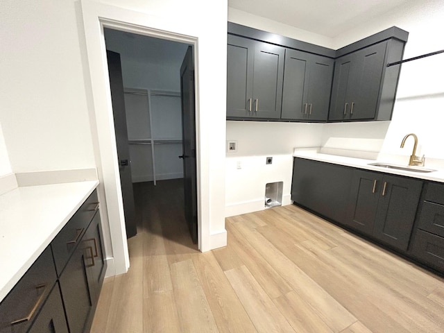 laundry area featuring cabinets, sink, light hardwood / wood-style flooring, washer hookup, and hookup for an electric dryer