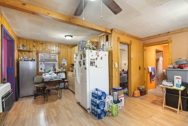 kitchen with stainless steel refrigerator, wooden walls, heating unit, white refrigerator with ice dispenser, and light hardwood / wood-style floors