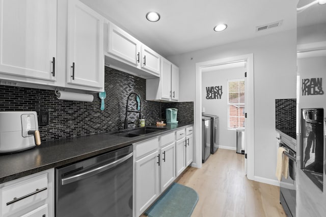 kitchen with stainless steel appliances, light hardwood / wood-style floors, white cabinetry, sink, and decorative backsplash