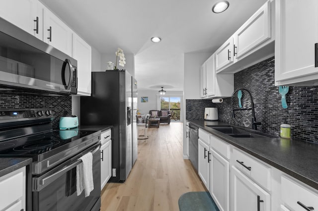 kitchen with white cabinetry, stainless steel appliances, sink, and light hardwood / wood-style flooring