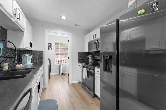 kitchen featuring light hardwood / wood-style floors, decorative backsplash, sink, white cabinetry, and appliances with stainless steel finishes