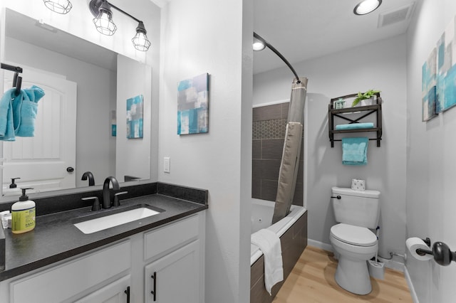 full bathroom featuring toilet, vanity, shower / bath combo with shower curtain, and hardwood / wood-style flooring