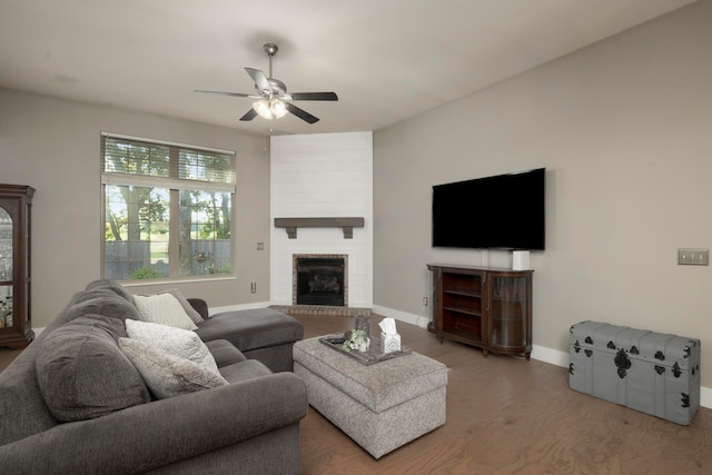 living room featuring wood-type flooring, a brick fireplace, and ceiling fan