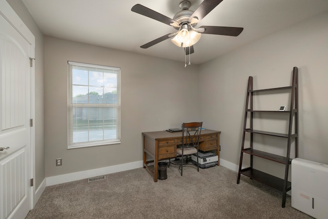 carpeted office space with ceiling fan