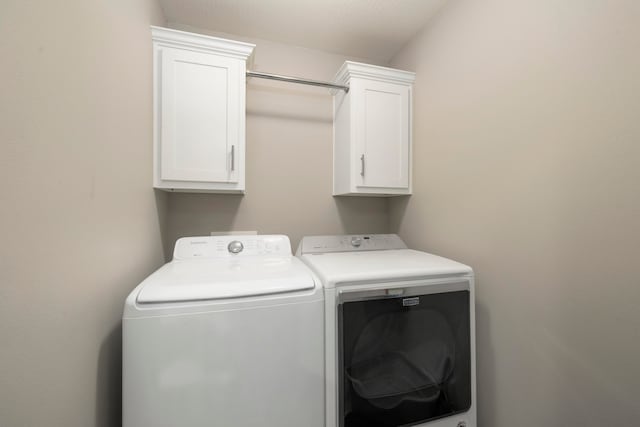 laundry room with cabinets and washing machine and clothes dryer