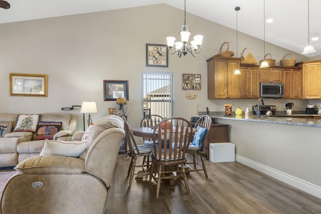 dining room featuring high vaulted ceiling, dark wood-type flooring, and a notable chandelier