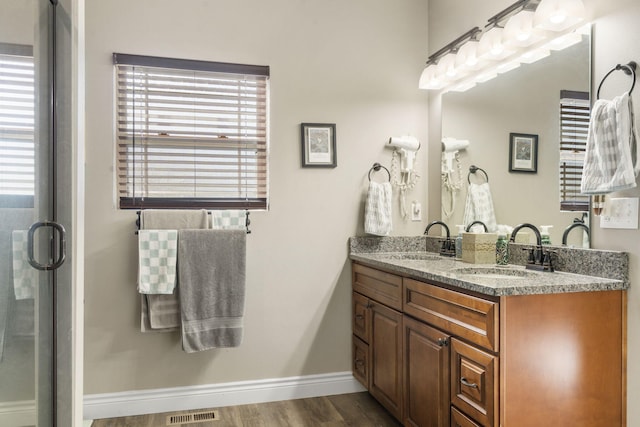 bathroom featuring wood-type flooring, vanity, and walk in shower