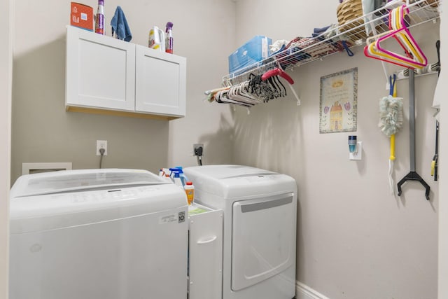 clothes washing area featuring cabinets and washer and dryer