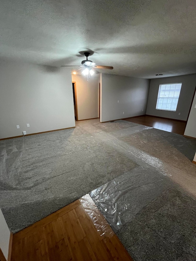 empty room featuring ceiling fan, wood-type flooring, and a textured ceiling