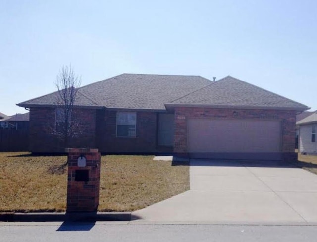 ranch-style house featuring a front lawn and a garage