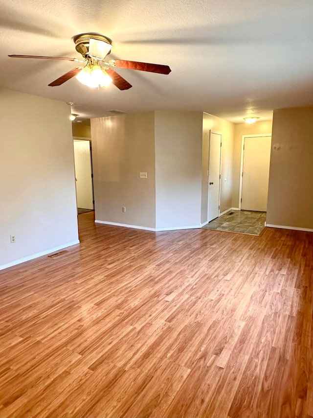 empty room featuring ceiling fan and light wood-type flooring