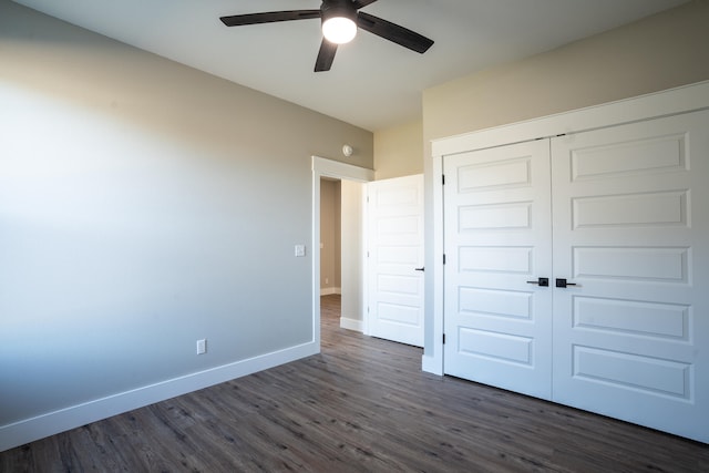 unfurnished bedroom with dark wood-type flooring, a closet, and ceiling fan